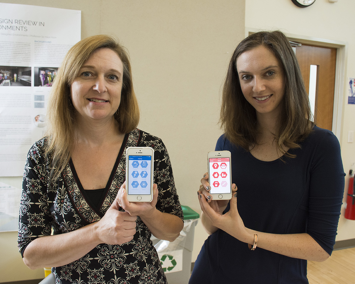 Doctoral students Kristen Aldred Cheek, left, and Casey Franklin demonstrate their Humble Bee app, which rewards students for sustainable behaviors.