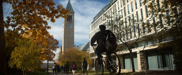 Student biking towards Ho Plaza