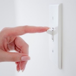 Hand reaching to turn out a light switch