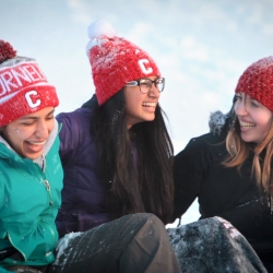 Three girls laughing in snow