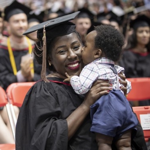 MBA grad holds her child