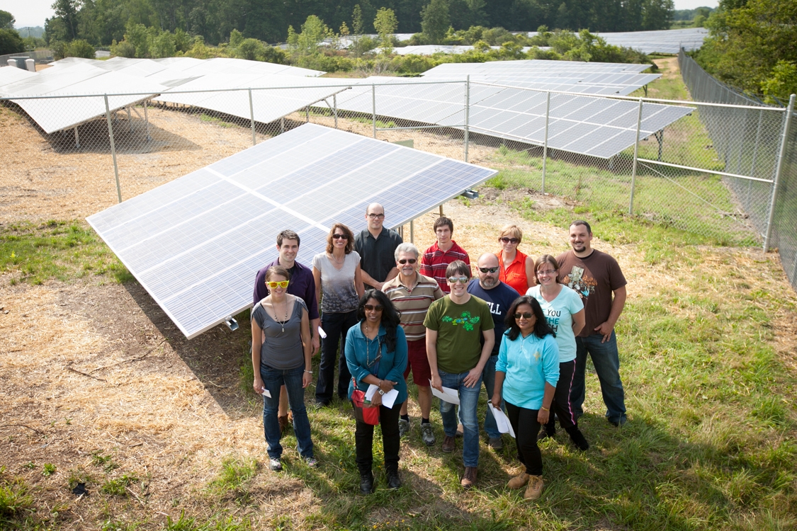 A group of student poses in front of Snyder Farm's solar panels