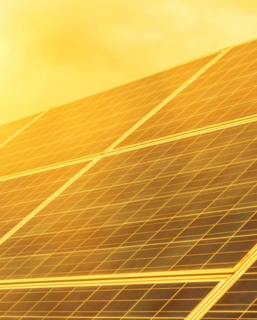 Solar panel with sun beating down on it.